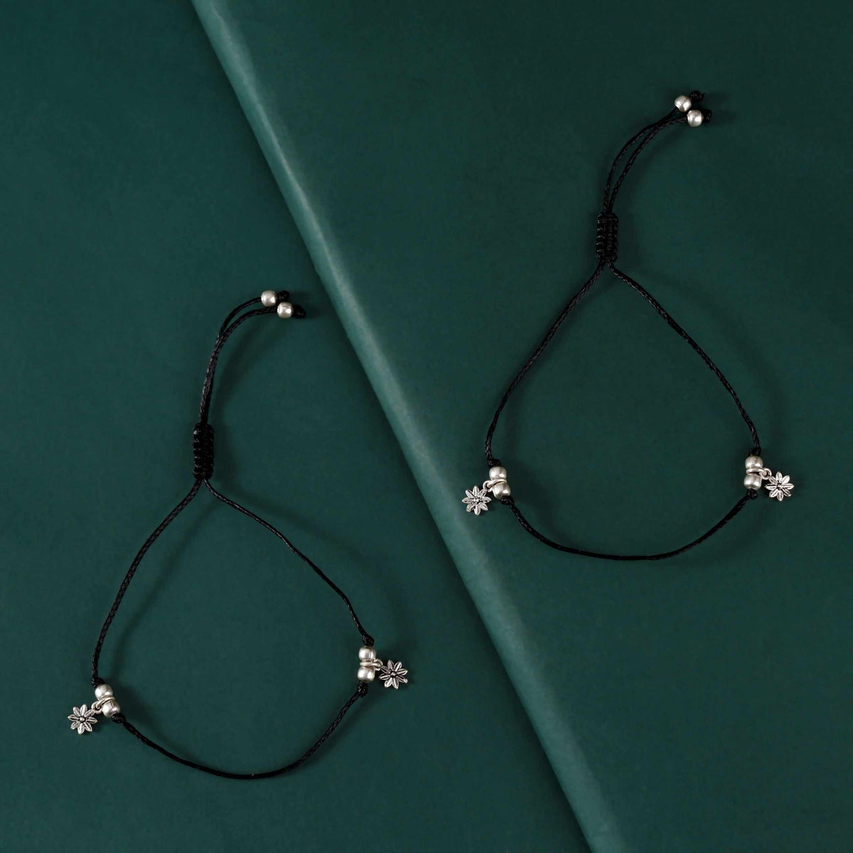 Pure Silver Floral Charms Anklets featuring black thread with oxidized silver floral charms and silver beads on adjustable ties