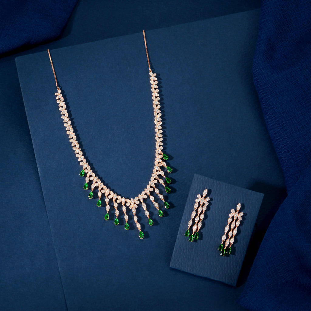 Rose Gold necklace and earring set with white CZ stones and emerald-green teardrop fringe for a bold, elegant look.