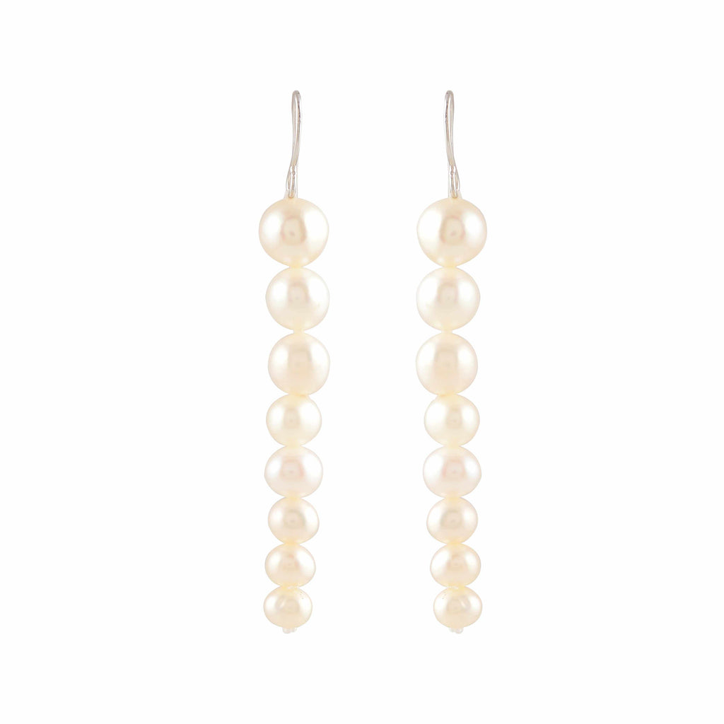 Pearl Descent drop earrings featuring a graduated line of round white pearls with silver hooks for elegant wear.
