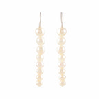 Pearl Descent drop earrings featuring a graduated line of round white pearls with silver hooks for elegant wear.