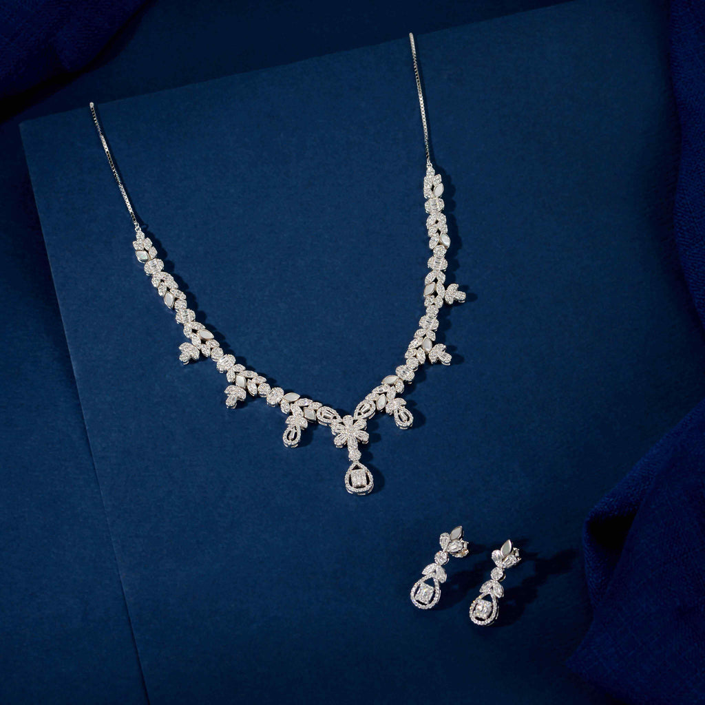 Silver Baguette Floral Set featuring a silver necklace and matching drop earrings with clear baguette, marquise, and round stones in floral patterns
