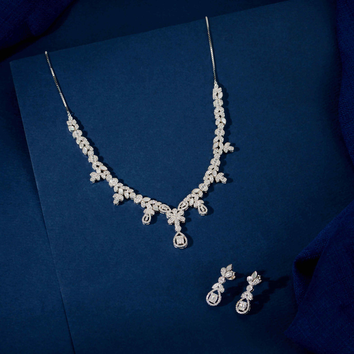Silver Baguette Floral Set featuring a silver necklace and matching drop earrings with clear baguette, marquise, and round stones in floral patterns