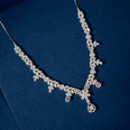 Silver Baguette Floral Set featuring a silver necklace with baguette, marquise, and round CZ stones in floral clusters and a teardrop pendant