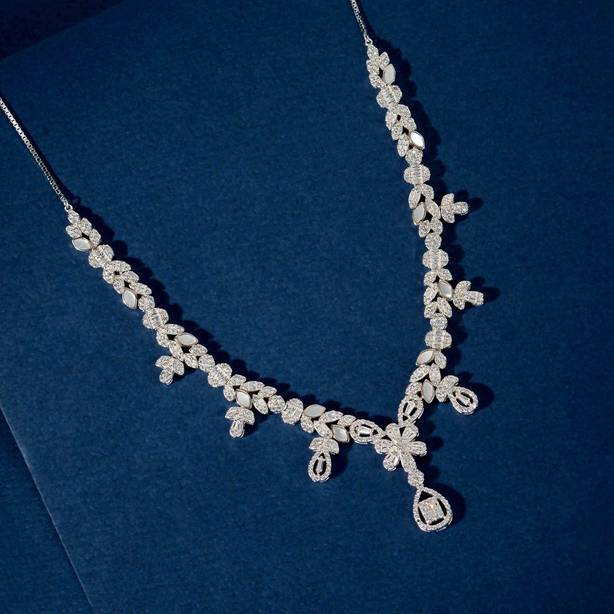 Silver Baguette Floral Set featuring a silver necklace with baguette, marquise, and round CZ stones in floral clusters and a teardrop pendant
